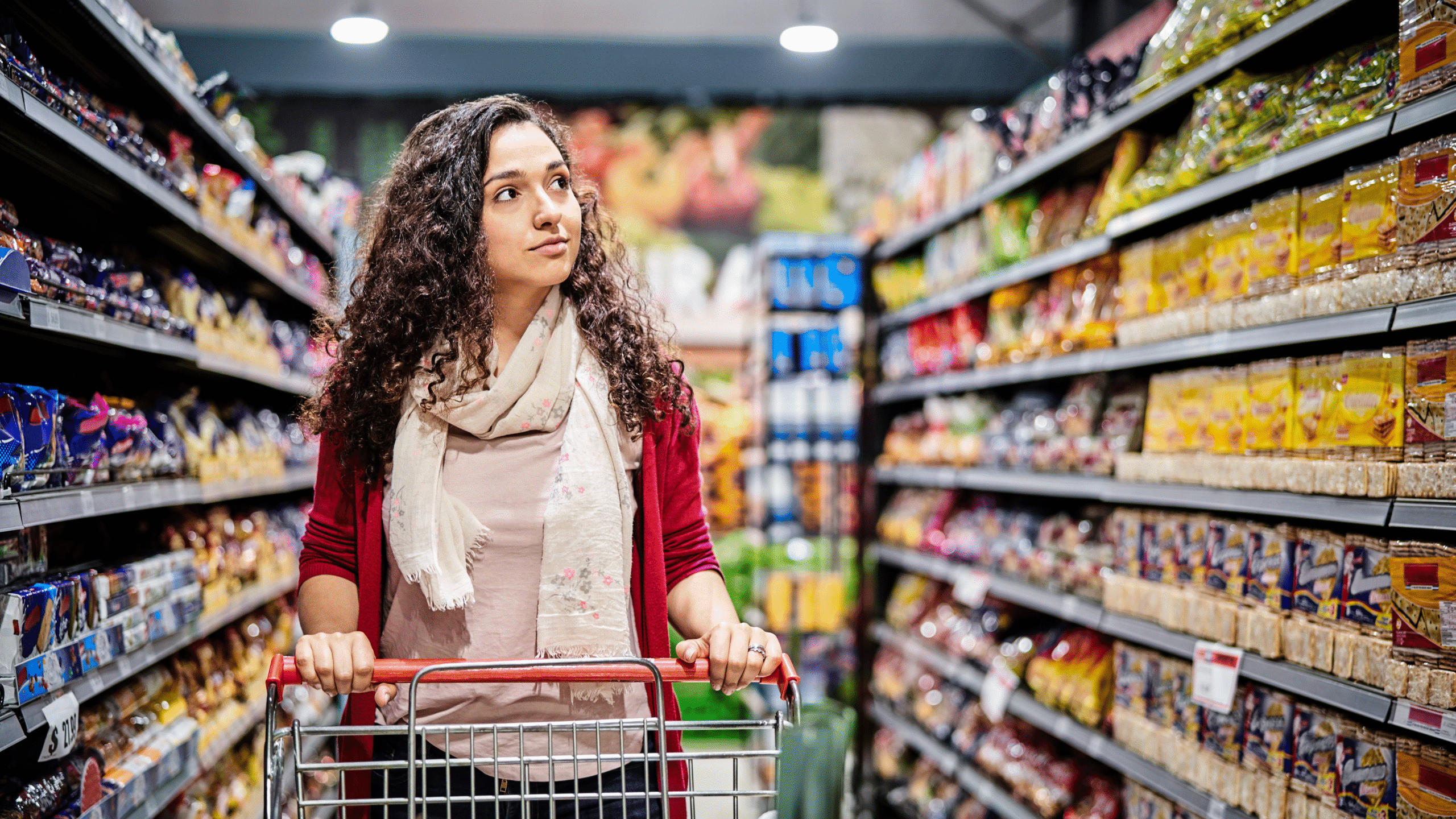 Customer shopping in supermarket aisle with grocery products and retail store shelves